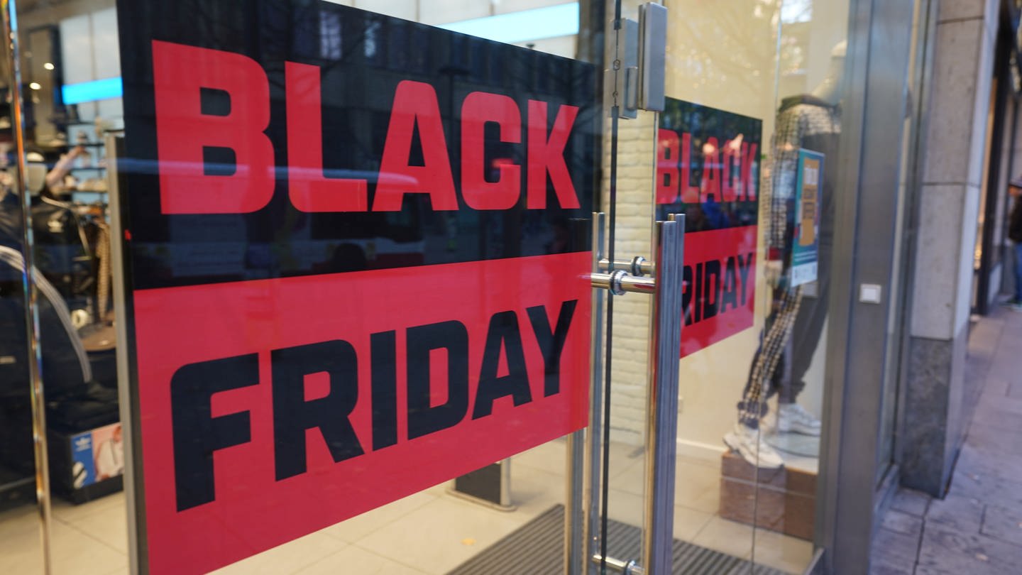 Ein Plakat mit der Aufschrift „Black Friday“ hängt in einem Schaufenster eines Geschäfts in der Innenstadt.