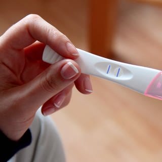 Eine Frau hält einen positiven Schwangerschaftstest in der Hand. Frauen, die ungewollt schwanger wurden, können nach der Empfehlung einer Expertenkommission auf eine Reform des Abtreibungsrechts hoffen.