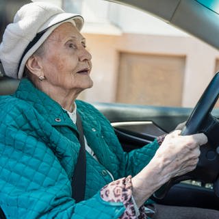 Senior woman driving car on road model released