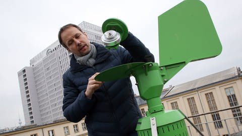 Matthias Werchan, Landschaftsökologe der Stiftung Deutscher Polleninformationsdienst (PID), kontrolliert auf dem Dach der Hautklinik der Charité in Berlin eine Pollenfalle.