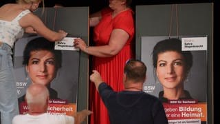 Mitglieder hängen Plakate für die Präsentation der Kampagne für die Landtagswahl des Bündnis Sahra Wagenknecht - Vernunft und Gerechtigkeit (BSW) auf