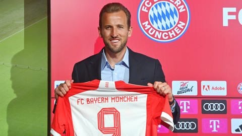 Harry Kane präsentiert sein Bayern-München-Trikot. Er ist der teuerste Einkauf der Bundesligageschichte.