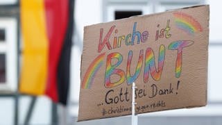 Ein Plakat auf einer Demo gegen die AfD mit der Aufschrift: "Kirche ist bunt".