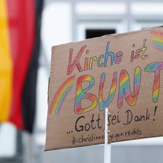 Ein Plakat auf einer Demo gegen die AfD mit der Aufschrift: "Kirche ist bunt".