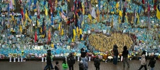 Menschen gehen am Denkmal für gefallene Soldaten auf dem Unabhängigkeitsplatz in Kiew vorbei