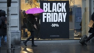 Passanten gehen am Black Friday an einem Schaufenster an der Bahnhofstraße vorbei.