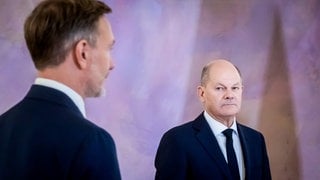 Bundeskanzler Olaf Scholz (rSPD) schaut auf Christian Lindner (FDP), ehemaliger Bundesminister der Finanzen im Schloss Bellevue.