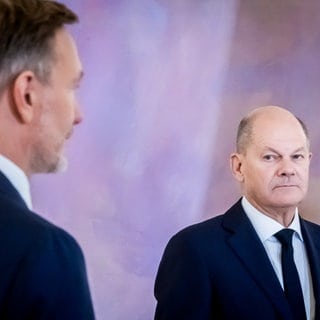 Bundeskanzler Olaf Scholz (rSPD) schaut auf Christian Lindner (FDP), ehemaliger Bundesminister der Finanzen im Schloss Bellevue.