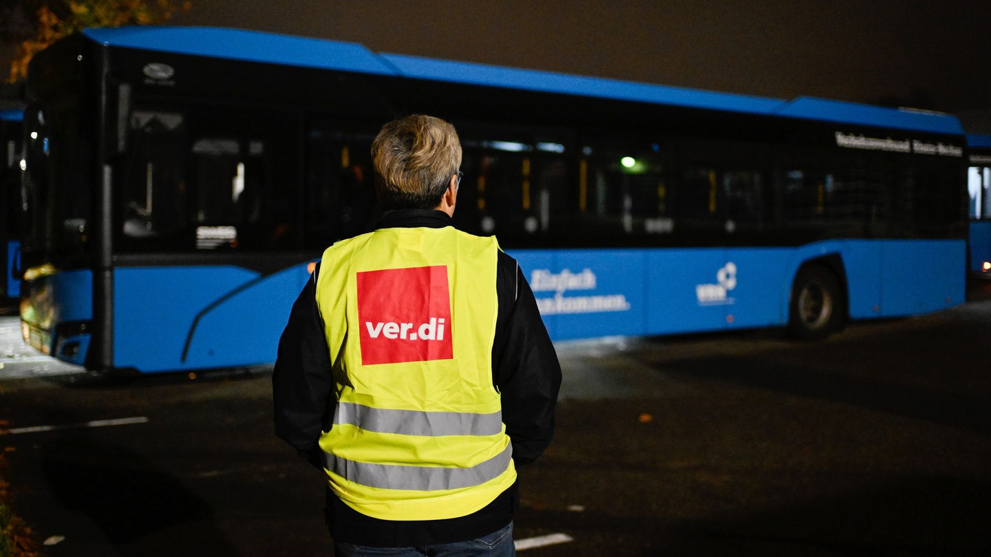 Eine Streikende steht bei einem Warnstreik der Gewerkschaft ver.di am 6. November auf dem Gelände der SWEG (Südwestdeutsche Landesverkehrs-GmbH) vor einem Bus. Der aktuelle Warnstreik im ÖPNV soll bis Mittwoch andauern.