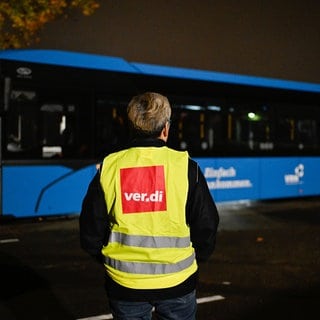 Eine Streikende steht bei einem Warnstreik der Gewerkschaft ver.di am 6. November auf dem Gelände der SWEG (Südwestdeutsche Landesverkehrs-GmbH) vor einem Bus. Der aktuelle Warnstreik im ÖPNV soll bis Mittwoch andauern.