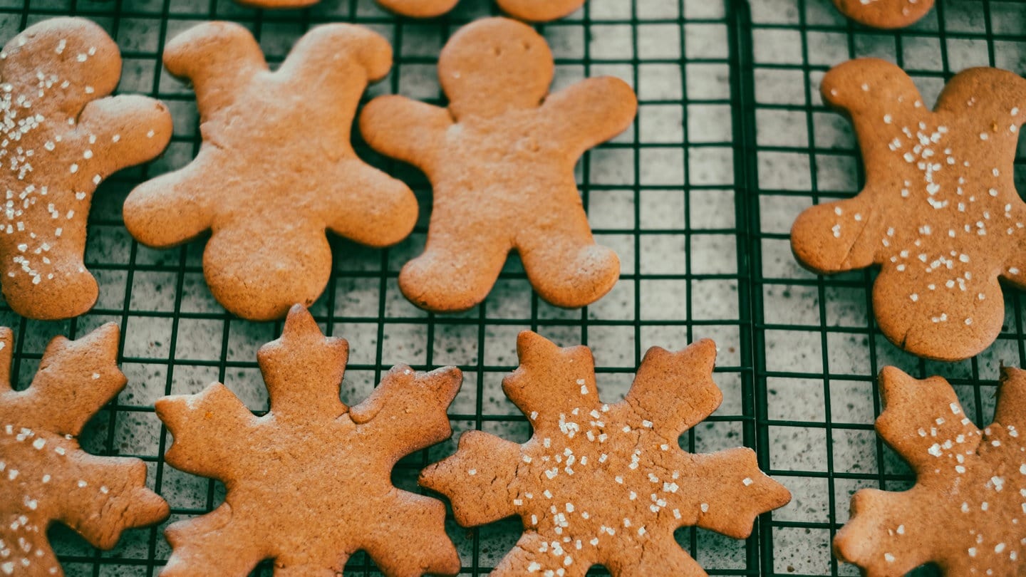 Blech mit Lebkuchen in Form von Schneeflocken und Weckmännern: Einige Zutaten wie Kakao und Butter werden teurer, aber kann man beim Backen Geld sparen?