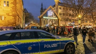 Ein Polizeifahrzeug vor dem Weihnachtsmarkt in Stuttgart. Mehr Beamtinnen und Beamte sollen für mehr Sicherheit auf den Weihnachtsmärkten in Baden-Württemberg sorgen.