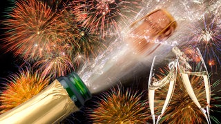 Jahreswechsel 2024 2025 mit Feuerwerk und poppender Sektflasche