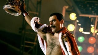 Queen-Sänger Freddy Mercury hält eine Krone in der Hand