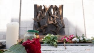 Blumen und Kerzen sind vor der Synagoge in Stuttgart abgelegt.