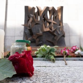 Blumen und Kerzen sind vor der Synagoge in Stuttgart abgelegt.