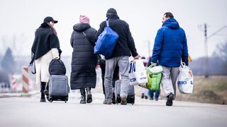 Geflüchtete Ukrainer gehen nach ihrem Grenzübertritt von Schehyni in der Ukraine nach Medyka in Polen. Zahlreiche Ukrainer verlassen nach Militäraktionen Russlands auf Ukrainischem Staatsgebiet das Land.