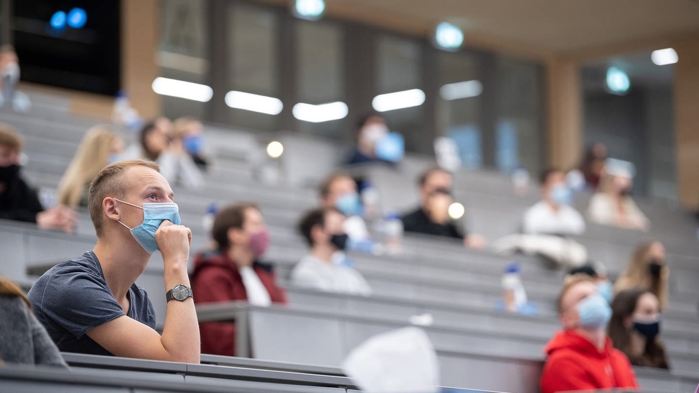 Studierende mit Mund- und Nasenmaske sitzen in einem Hörsaal der Universität Hohenheim in Baden-Württemberg.
