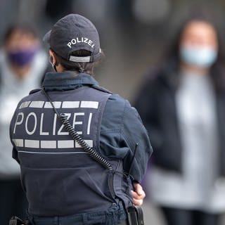 Eine Polizistin steht in der Innenstadt. In der Landeshauptstadt treten strengere Corona-Regeln in Kraft. Unter anderem gilt innerhalb des City-Rings eine Maskenpflicht.