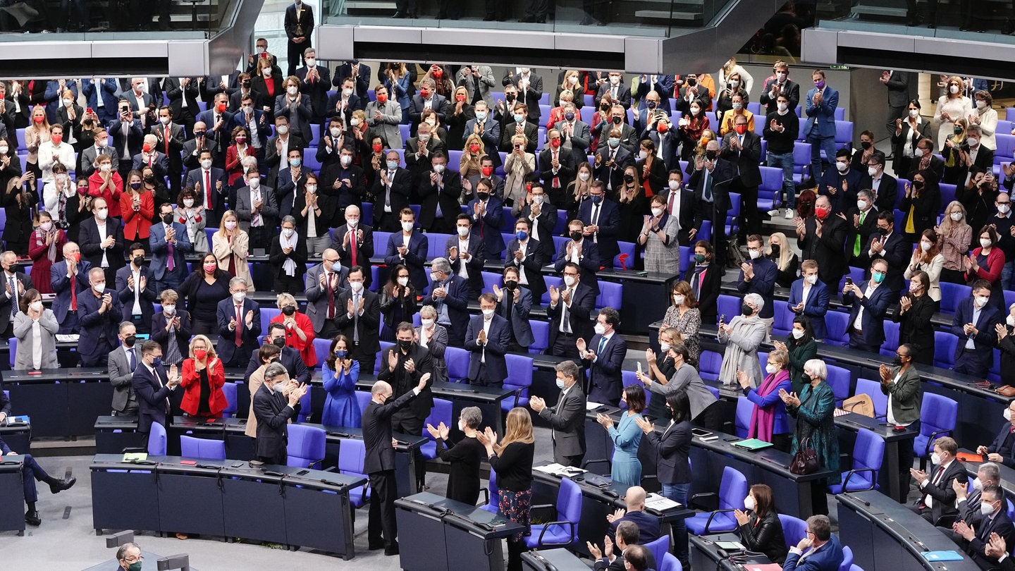 Die Abgeordneten applaudieren Olaf Scholz (M unten, SPD) nach seiner Wahl zum Bundeskanzler. Im Bundestag findet die Wahl und Vereidigung von Scholz zum Bundeskanzler und die Vereidigung der Bundesministerinnen und -minister der neuen rot-grün-gelben Bundesregierung statt. Scholz führt damit die erste Ampelkoalition aus SPD, Grünen und FDP auf Bundesebene an.