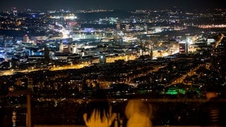 Junge Menschen genießen zur "Earth Hour" den Blick über die Stuttgarter Innenstadt bei Nacht. 