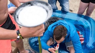 Ein Mann trinkt am 23.05.2015 während dem "Sputnik Springbreak" Musikfestival auf der Halbinsel Pouch bei Bitterfeld (Sachsen-Anhalt) Bier aus einem Trichter.