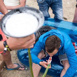 Ein Mann trinkt am 23.05.2015 während dem "Sputnik Springbreak" Musikfestival auf der Halbinsel Pouch bei Bitterfeld (Sachsen-Anhalt) Bier aus einem Trichter.