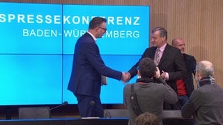 Die Fraktionsvorsitzenden im Landtag von Baden-Württemberg, Andreas Schwarz (Grüne) und Hans-Ulrich Rülke (FDP), schütteln sich auf der Landespressekonferenz in Stuttgart die Hand.