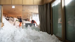 Schweiz, Schwaegalp: Männer versuchen den Schnee aus dem Hotel Säntis auf der Schwägalp zu entfernen. 