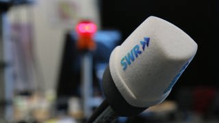 SWR Mikrofon vor unscharfem Hintergrund mit Rotlicht