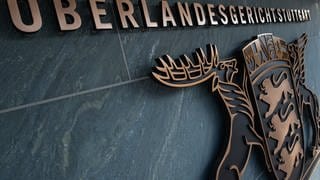 An dem Gebäude des Oberlandesgerichts (OLG Stuttgart) hängt unter dem Schriftzug das Wappen Baden-Württembergs.