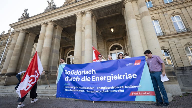 Vor dem "Gasgipfel" BW im Neuen Schloss in Stuttgart demonstrieren DGB-Mitglieder mit einem Transparent für Solidatität in der Energiekrise.