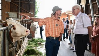 Winfried Kretschmann, Ministerpräsident von Baden-Württemberg, steht bei einem Besuch im Kuhstall des Bio Bauernhofes von Landwirt Friedhard Bühler