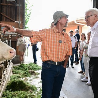Winfried Kretschmann, Ministerpräsident von Baden-Württemberg, steht bei einem Besuch im Kuhstall des Bio Bauernhofes von Landwirt Friedhard Bühler