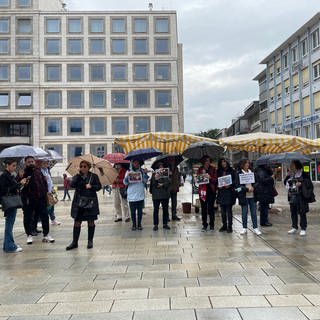 Auf dem Stuttgarter Markplatz demonstrieren im Regen Frauen und Männer für mehr Rechte von Frauen im Iran. 