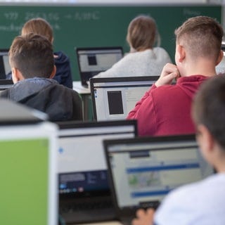 Schülerinnen und Schüler nehmen im Klassenzimmer einer 9. Klasse der Gemeinschaftsschule Leutenbach am Geografieunterricht mit Hilfe von Laptops und Tablets teil. (Archiv)