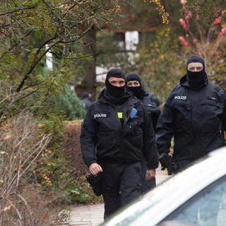 Polizisten gehen bei Ermittlungen in Berlin Wannsee. Die Bundesanwaltschaft hat 25 Menschen aus der sogenannten Reichsbürgerszene festnehmen lassen.