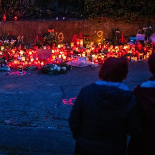 Zur blauen Stunde brennen zahlreiche Kerzen am Tatort eines Messerangriffs auf zwei Mädchen. Nach dem Angriff auf zwei Schülerinnen in Illerkirchberg bei Ulm ist Haftbefehl wegen Mordes und versuchten Mordes gegen den Verdächtigen erlassen worden. Eine 14-Jährige wurde bei der Attacke tödlich und ein 13 Jahre altes Mädchen schwer verletzt.