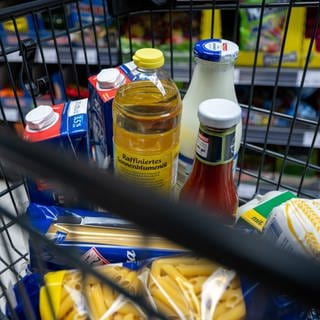 Lebensmittel liegen in einem Einkaufswagen in einem Supermarkt.