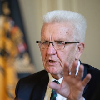Winfried Kretschmann (Grüne), Ministerpräsident von Baden-Württemberg, hebt im Gespräch mit Journalisten die linke Hand zu einer Geste. 
