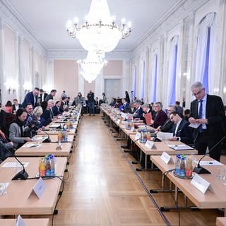 Politiker und Vertreter von Kommunen und Verbänden sitzen bei einem großen Flüchtlings-Gipfel, um Lösungen im Umgang mit Geflüchteten zu finden.