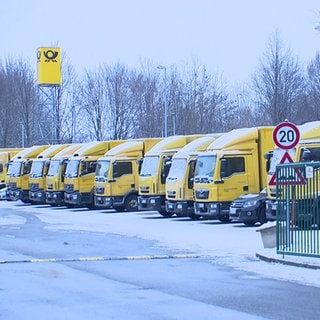 Zahlreiche Post-Zustellfahrzeuge stehen am 20.1.23 schneebedeckt auf dem Parkplatz der Niederlassung in Reutlingen