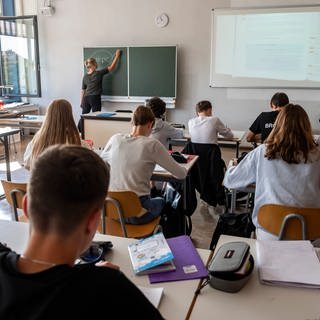 Lehrerin schreibt an Tafel, Symbolbild für Bayern will Leherer abwerben