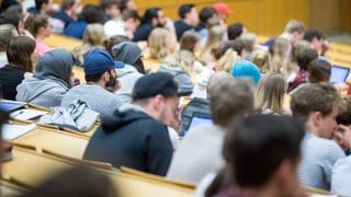 Studierende sitzen in einem Hörsaal in einer Vorlesung. 