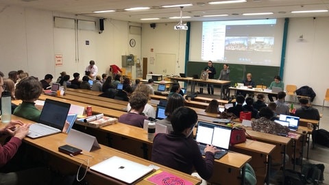 Studierende der Universität Heidelberg sitzen in einem Hörsaal.