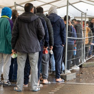 In der Landeserstaufnahmestelle (LEA) warten Flüchtlinge in einer Schlange vor der Essensausgabe. 