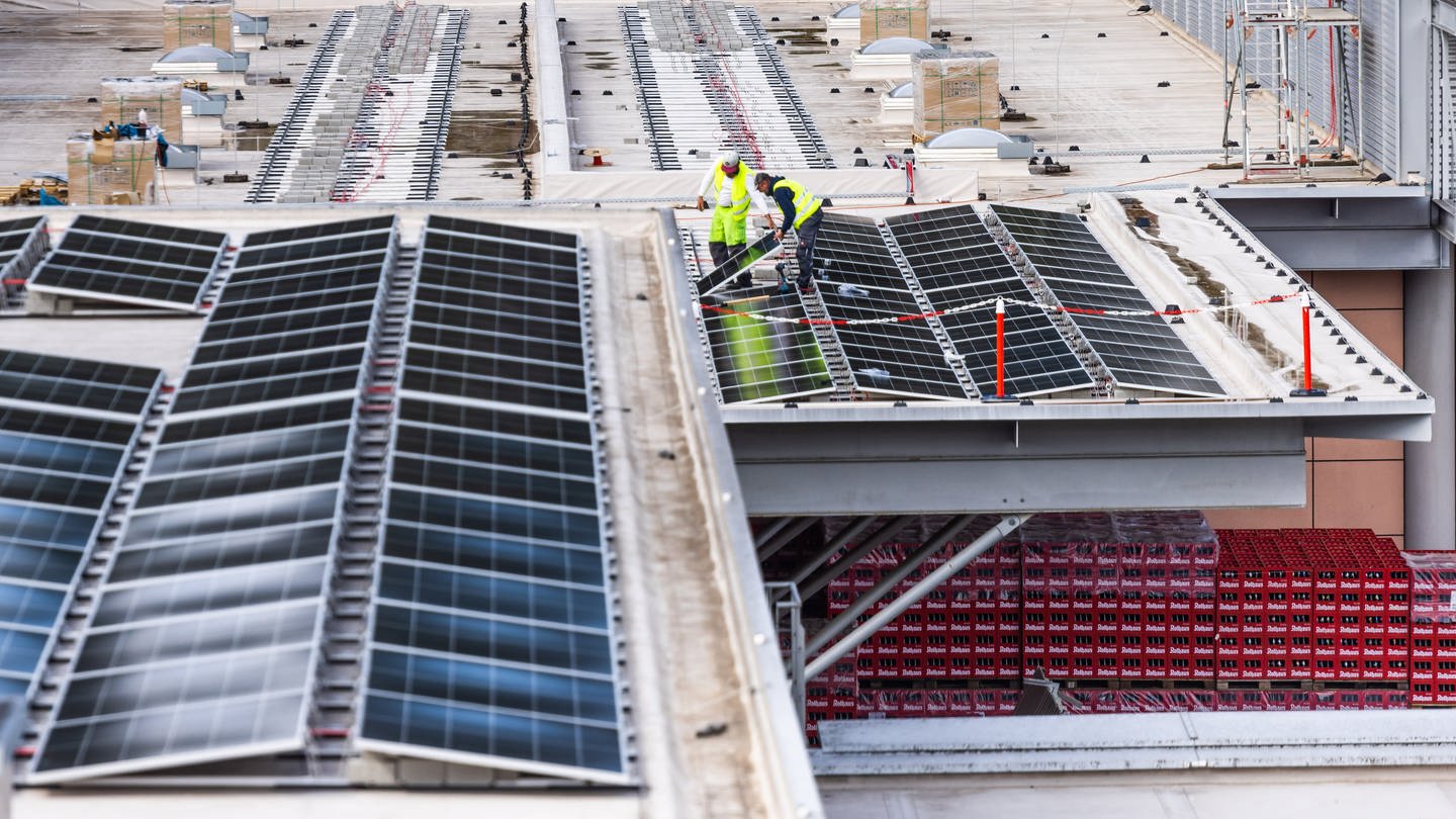 Arbeiter installieren ein Solarpaneel auf dem Betriebsgelände der Brauerei Rothaus. Die Badische Staatsbrauerei Rothaus AG will bis 2030 klimapositiv werden und installiert im Zuge dessen eine großflächige Photovoltaikanlage auf ihren Dächern.