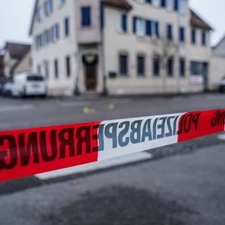 Nach Schüssen auf offener Straße in der Region Stuttgart hat die Polizei den Tatort mit einem Absperrband abgesperrt.