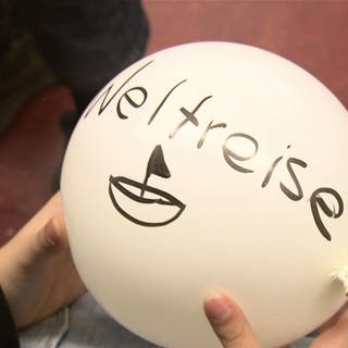 Schülerin hält Luftballon