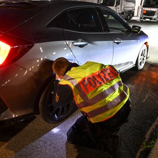 Ein Polizist kontrollieren ein Auto, das von einer Verkehrskontrolle am sogenannten Car-Freitag herausgezogen wurde. 